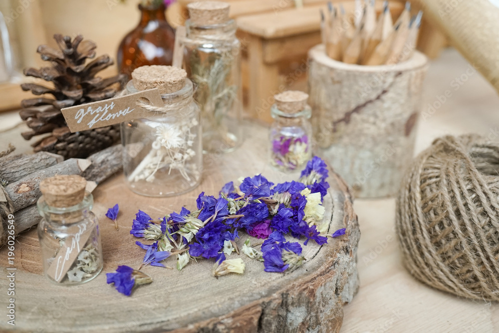 dried flowers on the wooden stump display with selective focus on the dried statice flowers (purple flowers). vintage and nostalgic still life.