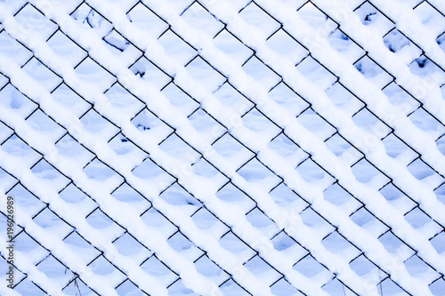 Iron fence in the snow. Lattice fence covered with snow