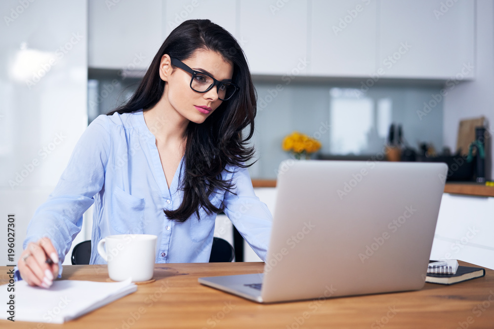 Young woman working on laptop in home office Young woman working on laptop in home office