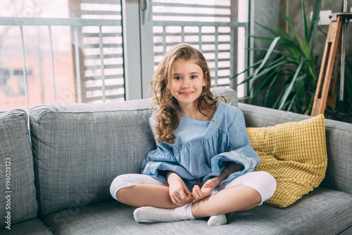 Portrait of little girl sitting on the couch 