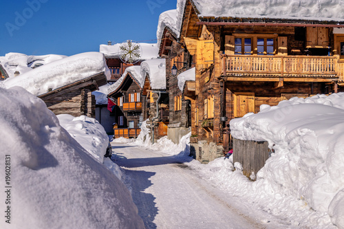 Wooden houses or chalets in Zinal, Switzerland on a beautiful day with a lot of snow. Zinal is a village in Switzerland, located in the municipality of Anniviers in the canton of Valais