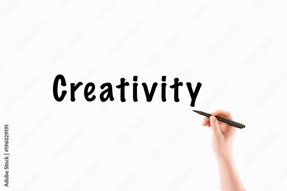 Fototapeta premium cropped image of woman writing creativity inscription isolated on white