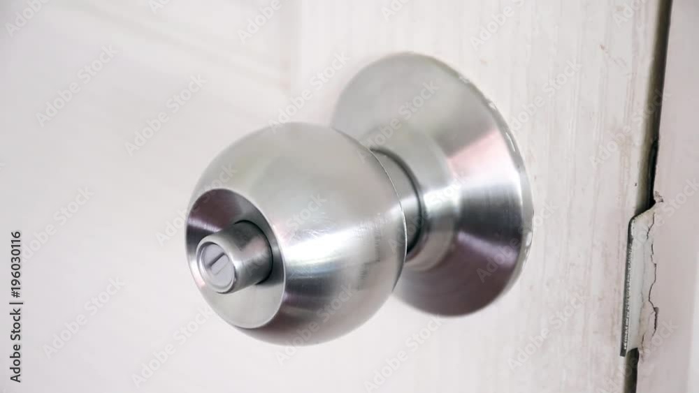close-up of metal knob unlocking on white wooden door close-up of metal knob unlocking on white wooden door
