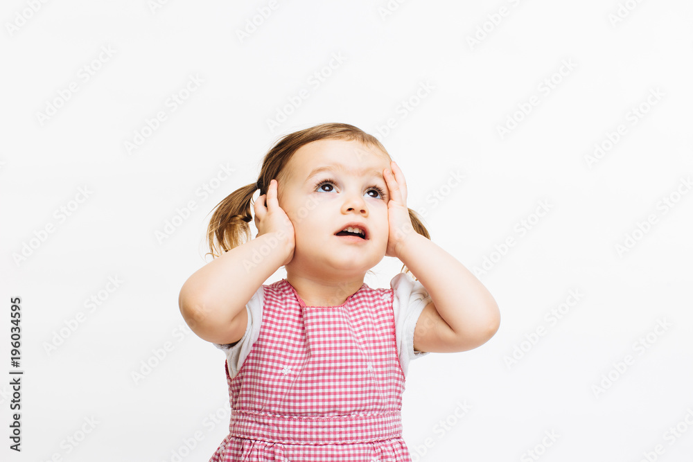 Preschool toddler girl holding her head and looking up, isolated on white background Preschool toddler girl holding her head and looking up, isolated on white background