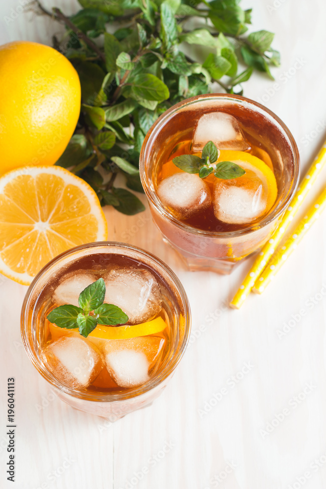 Refreshing citrus lemonade, summer drink. Ice tea with fresh lemon and mint on wooden background. Refreshment beverage concept. Refreshing citrus lemonade, summer drink. Ice tea with fresh lemon and mint on wooden background. Refreshment beverage concept.
