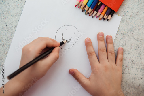 Little child hand drawing on the paper