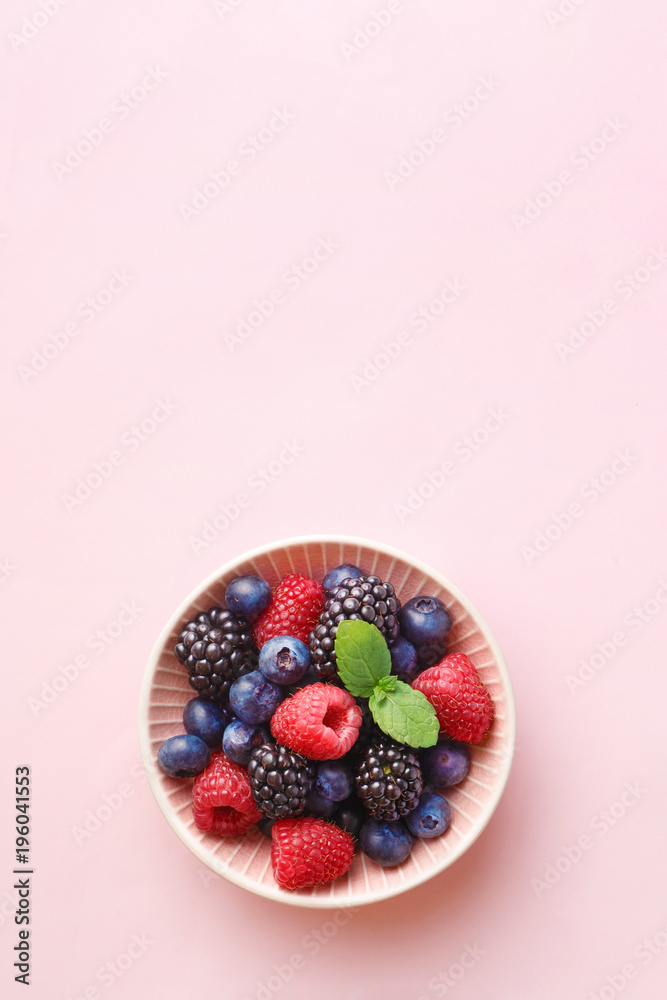 Berry (raspberry, blueberry, blackberry) fruits bowl on a pastel background. Top view. Copy space
