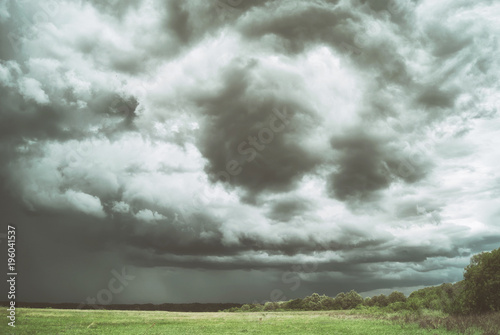 Large picturesque rain clouds over fields and meadows of Russia