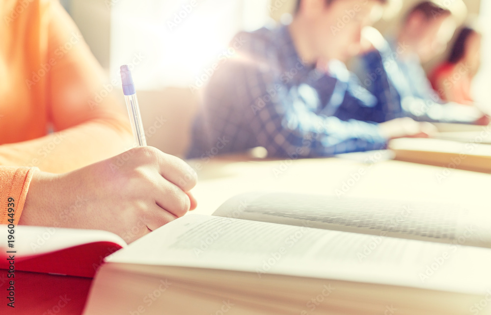 close up of students with book writing school test close up of students with book writing school test
