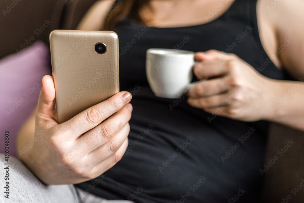 Woman with smartphone in hand and coffee drinking, people using mobile phone, modern technology concept Woman with smartphone in hand and coffee drinking, people using mobile phone, modern technology concept