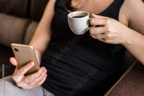 Women's hand with mobile phone and coffee cup, people using smartphone and modern technology in casual life