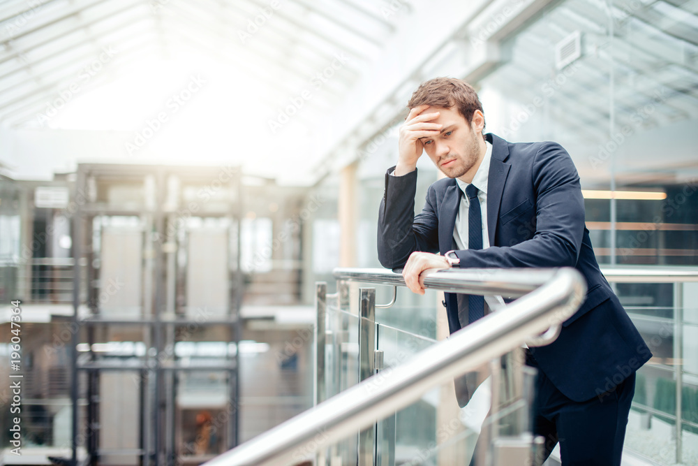 Young sad businessman covering his face with his hand. Man got bad news.Stress