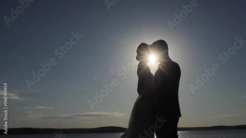 Wallpaper Mural Silhouetted couple in love embrace and enjoy intimate moment together sky background contrast shadow evening sun shine light beams. Man woman backlit hold each other kiss copy space. Believing in love Torontodigital.ca