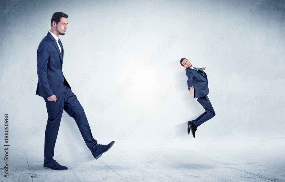 Big businessman kicking small businessman Big businessman kicking small businessman