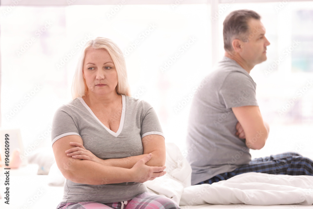 Senior couple with problem in relationship on bed at home Senior couple with problem in relationship on bed at home