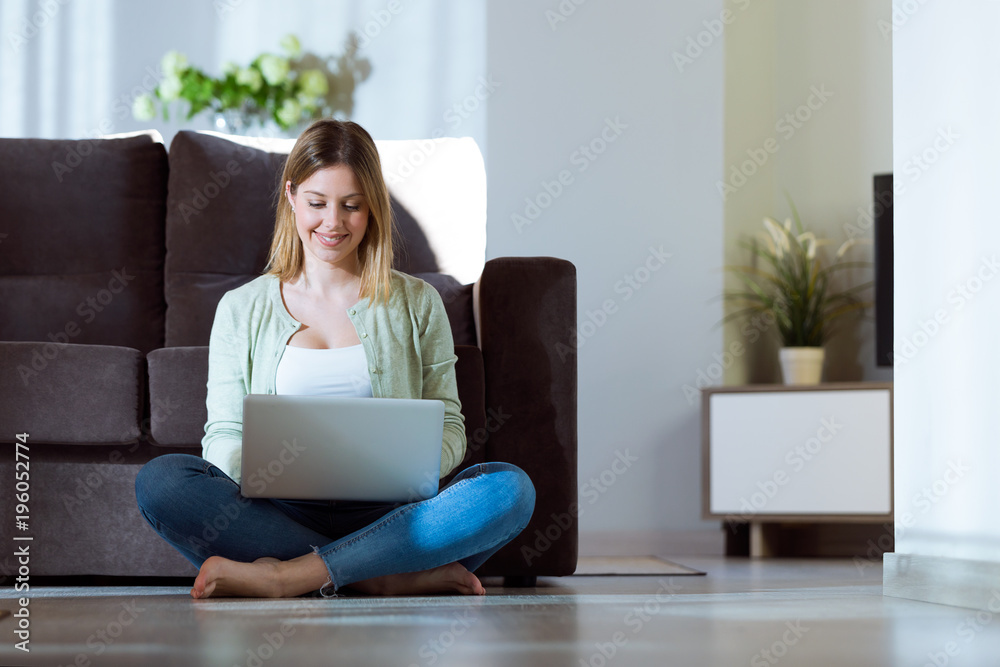 Beautiful young woman using her laptop at home. Beautiful young woman using her laptop at home.