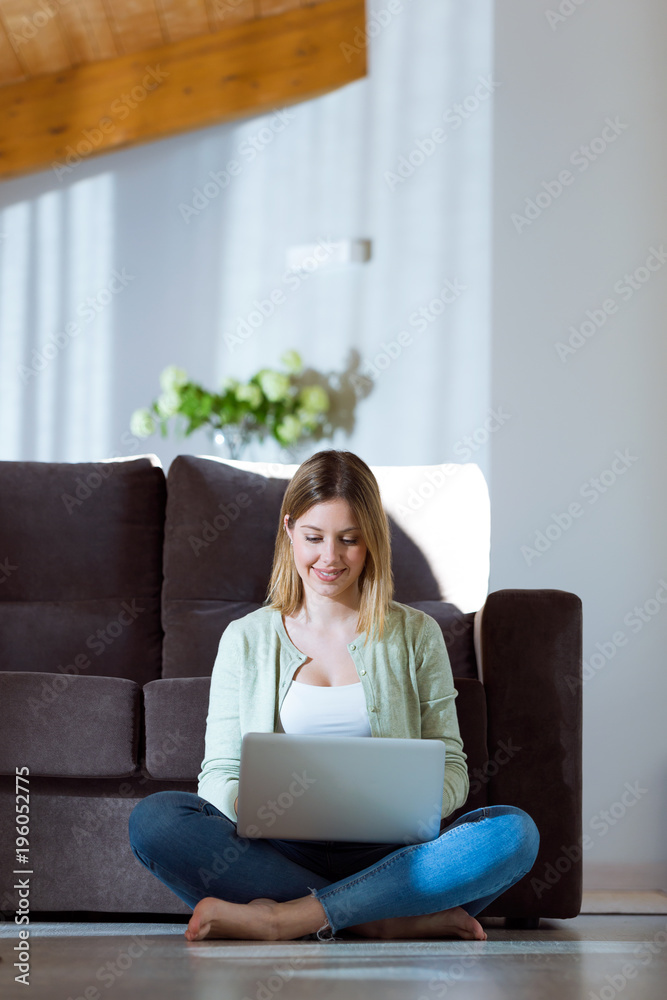 Beautiful young woman using her laptop at home. Beautiful young woman using her laptop at home.