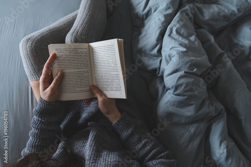 Bilde på lerret woman read book in bed with grey sheets