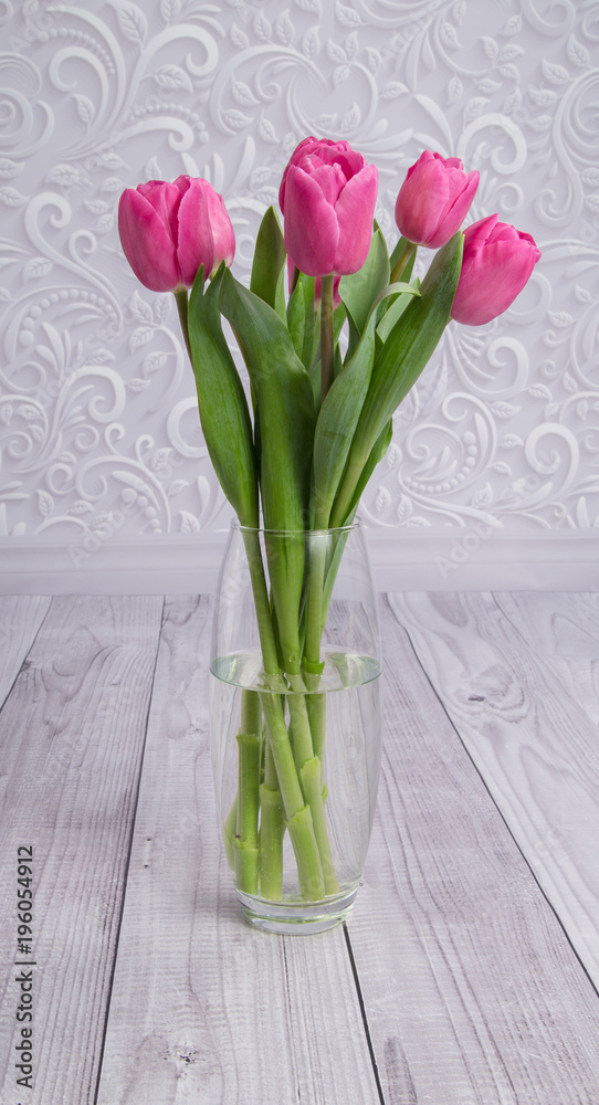 bouquet of pink fresh tulips in a glass vase on a gray background bouquet of pink fresh tulips in a glass vase on a gray background