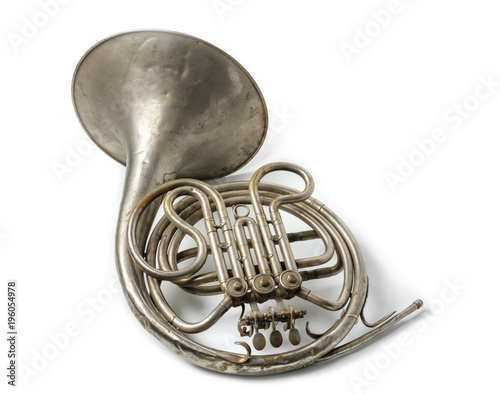 Old vintage rusty French horn on a withe surface