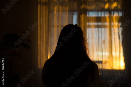 woman silhouette in front of window. sunrise in window. Wake up in morning