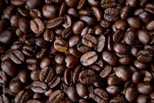Dark brown roasted coffee beans closeup background