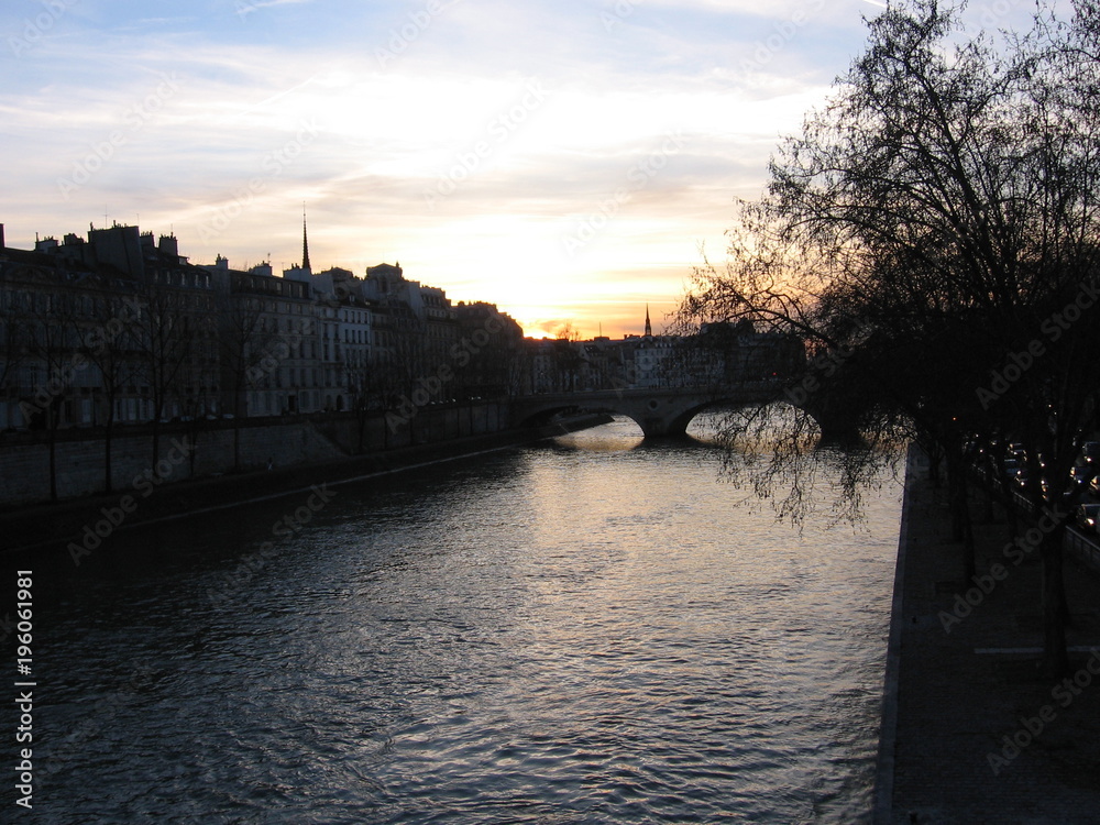 Sunset over a bridge on the Seine River in Paris, France
