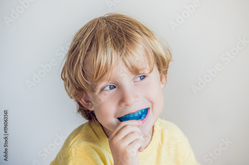 Three-year old boy shows myofunctional trainer to illuminate mouth breathing habit. Helps equalize the growing teeth and correct bite. Corrects the position of the tongue photo