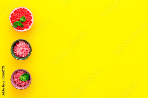 Natural citrus cosmetics with grapefruit salt on yellow background top view space for text