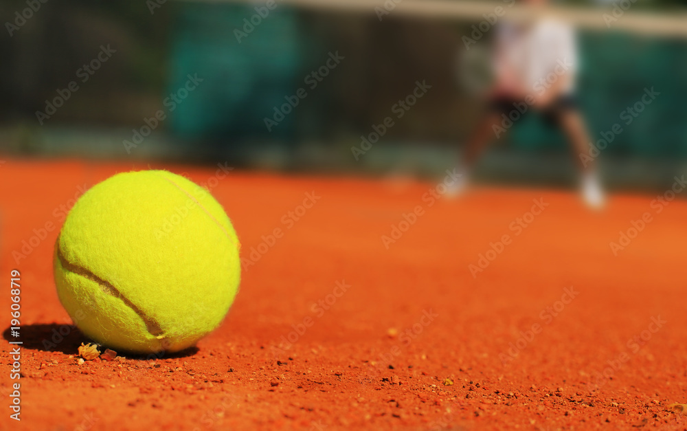 Tennis, yellow tennis ball on the ground and the player