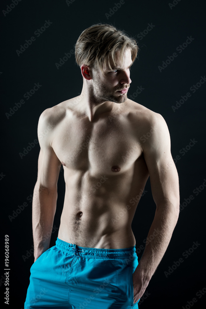 Fototapeta premium Man athlete show muscular torso in blue shorts