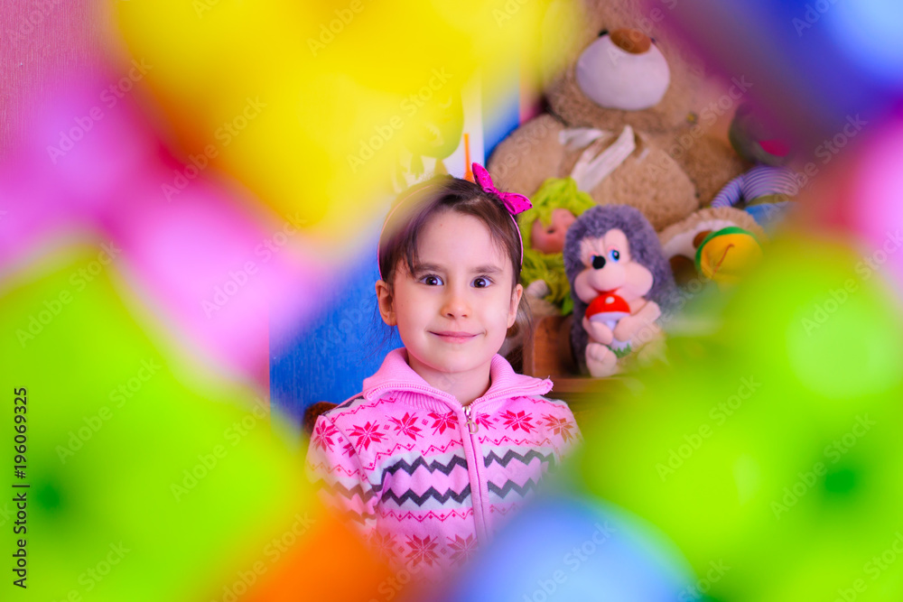 Fototapeta premium cute girl on the background of her toys smiling
