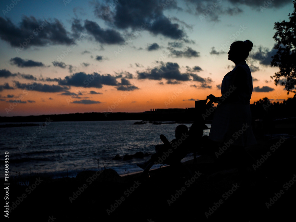 Obraz premium Silhouettes on the beach and the setting sun