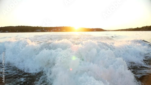 Slow motion wake of a large boat at sunset on the water photo