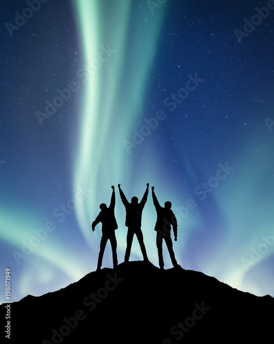 Silhouette of a team on the northen light backgroun. Concept and idea of active life