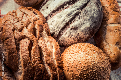 Freshly baked different types of bread - food background