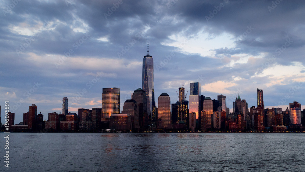 Panoramic view of Manhattan skyline with its reflection in Hudson river at dusk from New Jersey pier. New York, USA