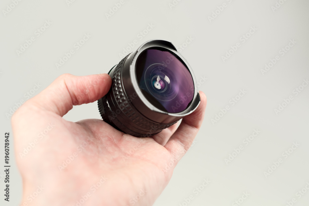Old lens in hands on a white background Old lens in hands on a white background
