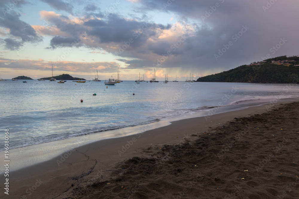 Early morning and sunrise at Malendure beach in Guadeloupe, Caribbean. Place famous for its dark sand and great diving conditions at nature reservation 