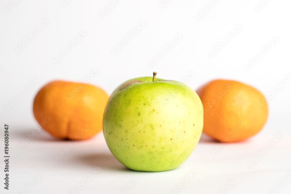 Green juicy apple with 2 mandarins on a white background with copyspace Green juicy apple with 2 mandarins on a white background with copyspace