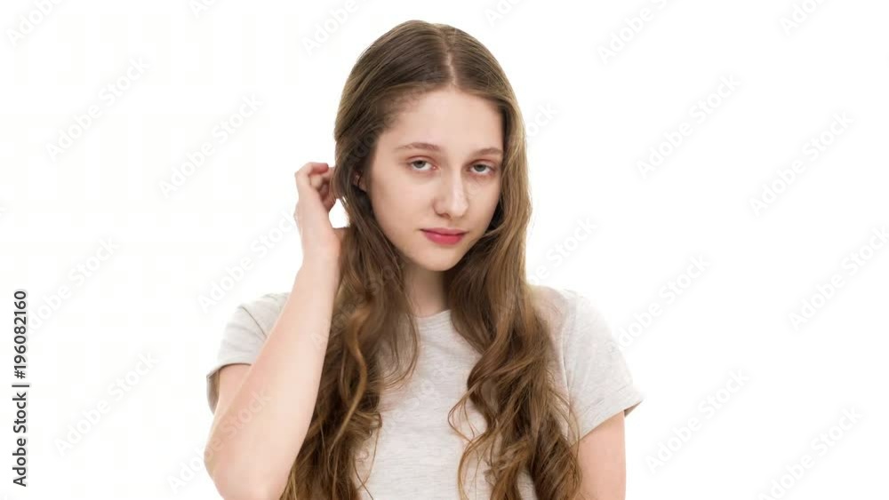 Portrait of cute caucasian woman having playful look and touching her long auburn hair with smile, over white background closeup. Concept of emotions Portrait of cute caucasian woman having playful look and touching her long auburn hair with smile, over white background closeup. Concept of emotions