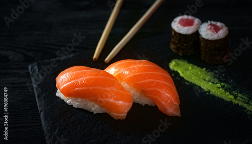 two sushi with salmon on stone