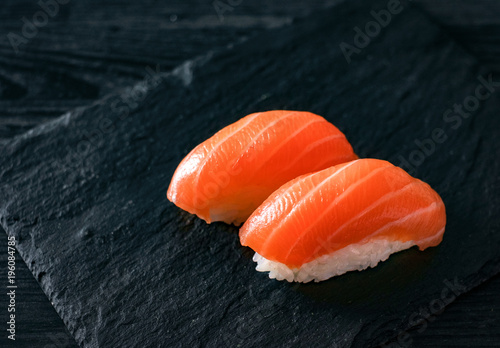 two sushi with salmon on stone