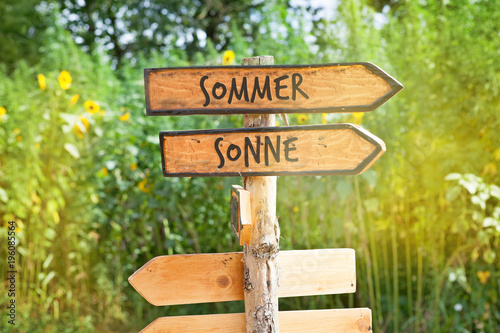 Wooden direction sign with the German words summer and sun (Sommer, Sonne)