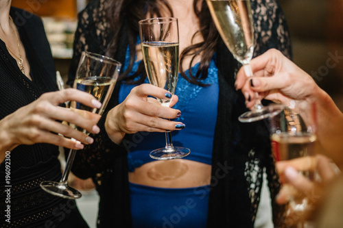 Group of partying girls clinking flutes with sparkling wine