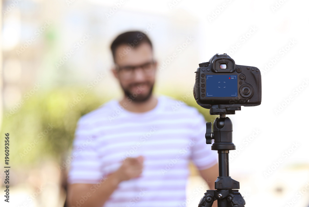 Young blogger recording video outdoors