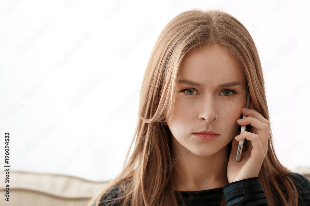 Young woman talking on mobile phone at home Young woman talking on mobile phone at home