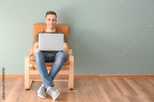 Young man using laptop indoors