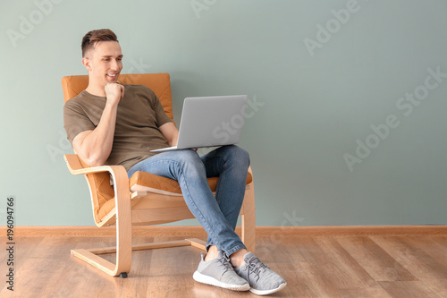 Young man using laptop indoors