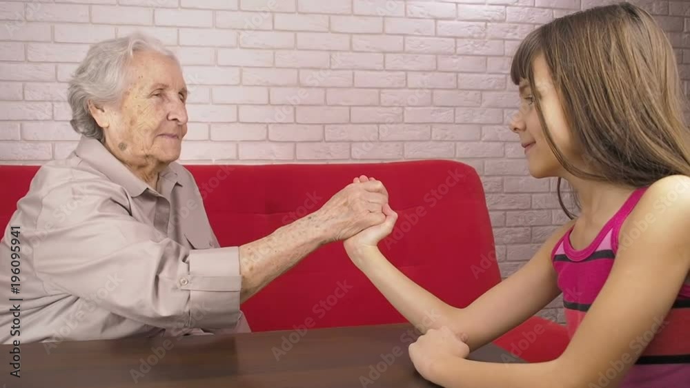 An elderly woman is playing with a child. Grandmother with granddaughter.